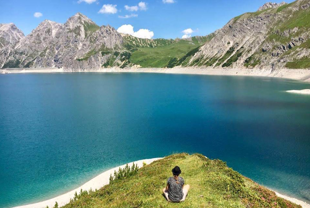 bild von einem bergsee an dem nora sonnenberg sitzt.